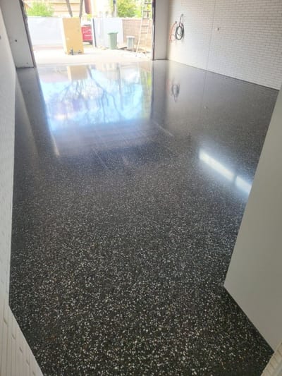 High-gloss polished concrete floor showing fine aggregate exposure in an open-plan living area