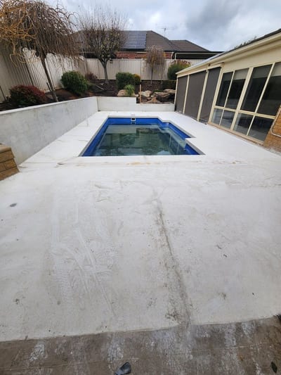Slip-rated honed concrete surround beside a backyard pool in Adelaide